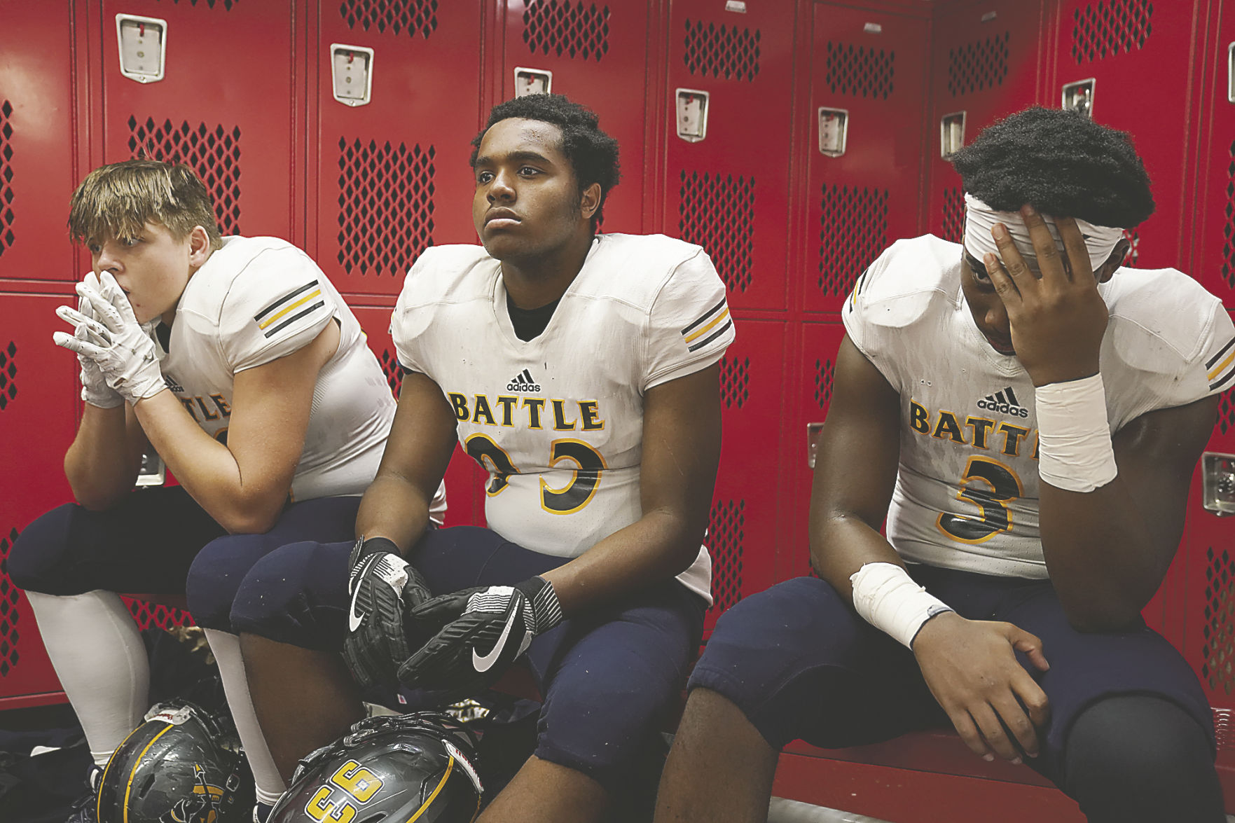Battle High School's Ethan Wiedmier, Keesean Payne and DaleShawn Coleman sit in the locker room at halftime